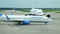 Passenger white and blue plane moves down the runway of the airfield