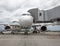 Passenger white plane at the airport. Boarding passengers through the boarding bridge. Loading and unloading of baggage