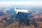 Passenger wide-body airplaneflies high above the mountain landscape