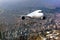 Passenger wide-body plane flies above the skyscrapers of the business center of the big city. Front view of