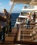 Passengers line the decks of a cruise ship on departure from port