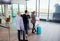 Passengers With Luggage Waiting For Their Turn At Airport Recept