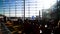 Passengers sitting on chairs in airport terminal, spacious sunlit waiting lounge