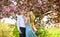 Passion concept. Man and woman in blooming garden. Couple spend time in spring tree garden. Loving people hug. Couple in