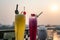 Passion fresh fruit juice with ice on outdoor table in cafe and bar. Pineapple and red dragon fruit. Urban lake on background