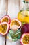 Passion fruit and its oil in glass bottle. Natural organic essence. White wooden background. Close up macro copy space for text