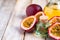 Passion fruit and its oil in glass bottle. Natural organic essence. White wooden background. Close up macro copy space for text