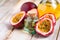 Passion fruit and its oil in glass bottle. Natural organic essence. White wooden background. Close up macro copy space for text