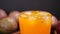 Passion fruit juice in drinking glass. Stirring passion fruit juicy with ice for healthy drink