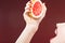 Passion Fruit Series. Closeup of Hand of Caucasian Girl Squeezing Grapefruit
