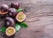 Passion fruits and its cross section with pulpy juice filled with seeds. Wooden background