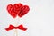 Passion valentine`s day background - sweet red lollipops hearts on white backdrop, copy space.