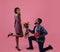 Passionate black man giving his sweetheart bouquet of roses and heart shaped gift for Valentine& x27;s Day on pink background