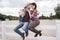 Passionate cowboy style couple kissing while sitting on fence at ranch