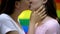 Passionate kiss of beautiful lesbians on rainbow flag background, love partners