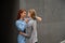 Passionate loving lesbian couple. Two beautiful young women hugging tenderly outdoors against a gray wall. LGBT commune