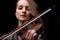 Passionate violin musician playing on black background