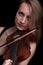 Passionate violin musician playing on black background