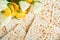 Passover celebration concept. Matzah, red kosher, white and yellow roses and walnut. Traditional ritual Jewish bread matzah,