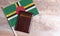 Passport and a Dominica flag on a wooden background