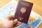 Passport in hand with a world\'s maps in background