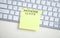 Password message written on sticky note in computer keyboard