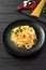 Pasta Aglio, Olio e Peperoncino, italian spaghetti with garlic, chili pepper and olive oil on a black plate on a