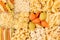 Pasta background assortment of different kinds italian macaroni in chess cells top view.