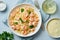 Pasta bavette with fried shrimps, bechamel sauce, mint leaf on blue table, top view, italian cuisine