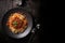 pasta bolognese with basil on a dark background top view