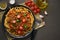 Pasta Bolognese bucatini with mincemeat and tomatoes, dark wooden background, top view, copy space