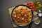 Pasta Bolognese bucatini with mincemeat and tomatoes, dark wooden background, top view, copy space