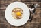 Pasta Carbonara on white plate with parmesan and yolk on dark wo