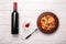 Pasta with cheese, cherry tomato , wineglass and bottle wine on white wooden boards