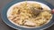Pasta with chicken, mushrooms, and Alfredo sauce close up on a plate.