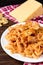 Pasta with chicken, spices and tomato sauce on dark wooden background