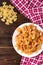 Pasta with chicken, spices and tomato sauce on dark wooden background