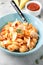 Pasta conchiglioni (conchiglie, shells) with tomato sauce, Parmesan cheese and thyme in a blue plate on a gray background.