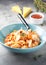 Pasta conchiglioni (conchiglie, shells) with tomato sauce, Parmesan cheese and thyme in a blue plate on a gray background.