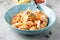 Pasta conchiglioni (conchiglie, shells) with tomato sauce, Parmesan cheese and thyme in a blue plate on a gray background.