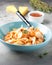 Pasta conchiglioni (conchiglie, shells) with tomato sauce, Parmesan cheese and thyme in a blue plate on a gray background.