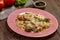 Pasta farfalle in bolognese sauce with meat on a plate on a wooden table.