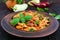 Pasta farfalle with chicken, tomato sauce and basil in a clay bowl
