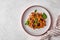 Pasta farfalle with eggplant, tomato sauce and basil on plate with napkin