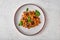 Pasta farfalle with eggplant, tomato sauce, cheese and basil on plate