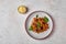 Pasta farfalle with eggplant, tomato sauce, cheese in bowl and basil on plate