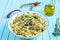 Pasta farfalle with turkey, pesto sauce and rosemary in serving plate over wooden turquoise background