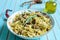 Pasta farfalle with turkey, pesto sauce and rosemary in serving plate over wooden turquoise background