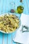 Pasta farfalle with turkey, pesto sauce and rosemary in serving plate over wooden turquoise background
