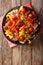 Pasta fettuccine with bell pepper and sausages close-up on a plate. vertical top view